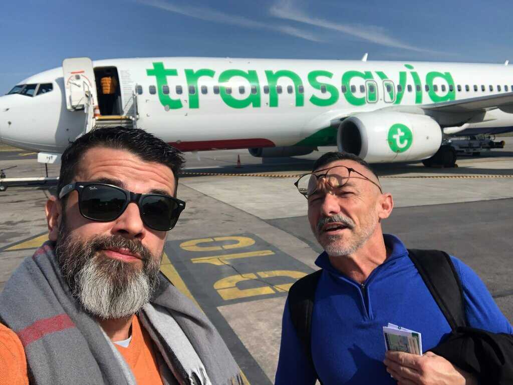 Sandy et Philippe devant un avion lors d’un voyage